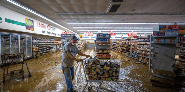 An Isom IGA employee helps clean up after flooding