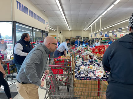 Faculty members line up grocery carts ready to race