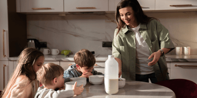 A mom puts breakfast on the table for her kids