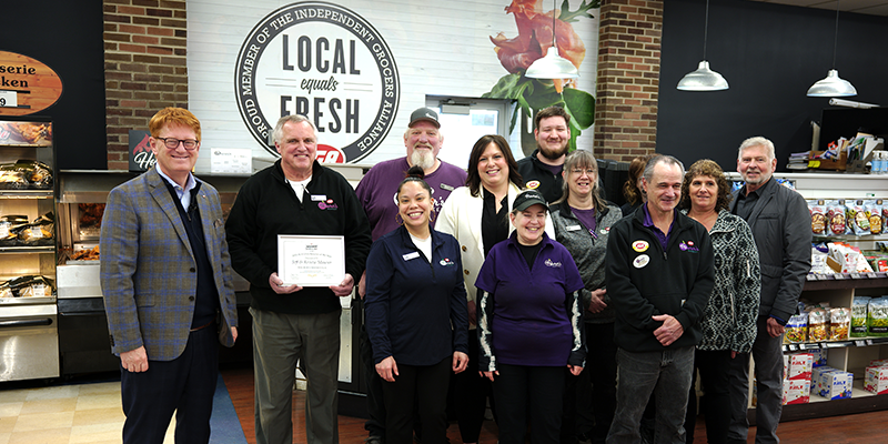 Group of grocery employees pose with award certificate