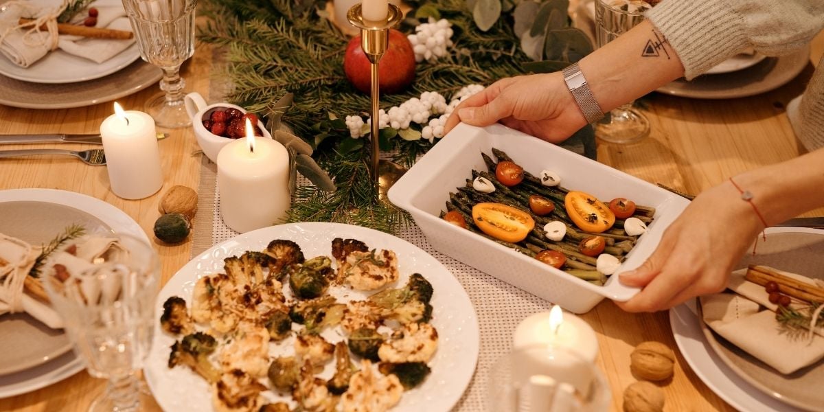 roasted broccoli and cauliflower, asparagus topped with roasted tomatoes on a holiday table