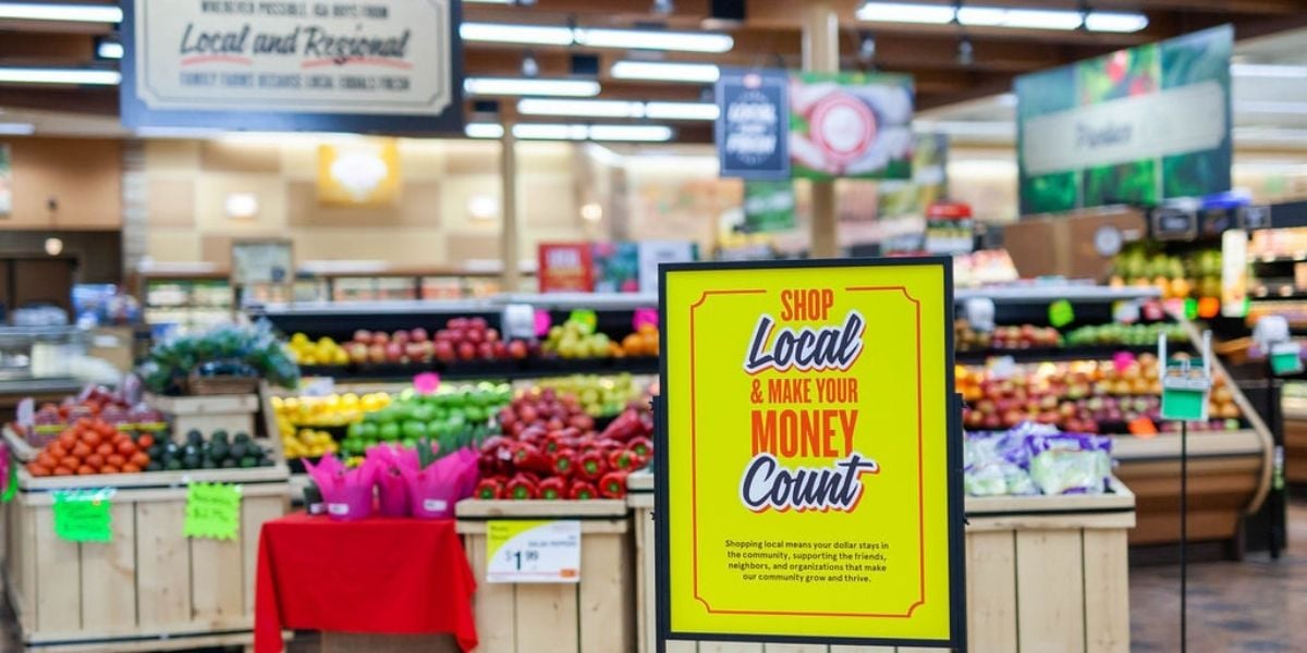 Shop Local and Make Your Money Count stanchion sign in grocery store