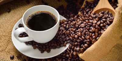 hot coffee in mug and coffee beans