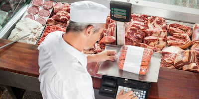 photo of man weighing meat
