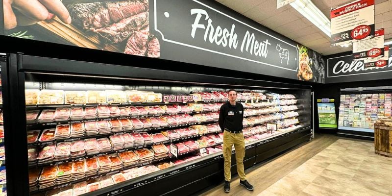 Isom IGA employee stands in front of the meat section