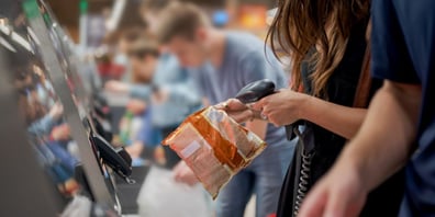 Person scans a bag at self-checkout lane