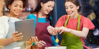 three friends cook together, use tablet for recipe