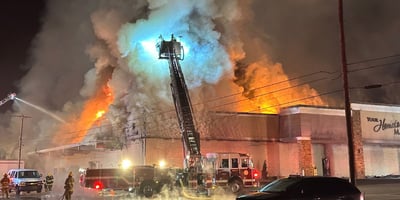 Firefighters try to put out the fire at Martin's Country Market, as plumes of smoke reach high in the sky.