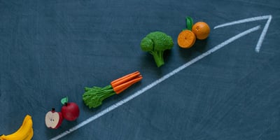 toy fruits and vegetables on a chalkboard
