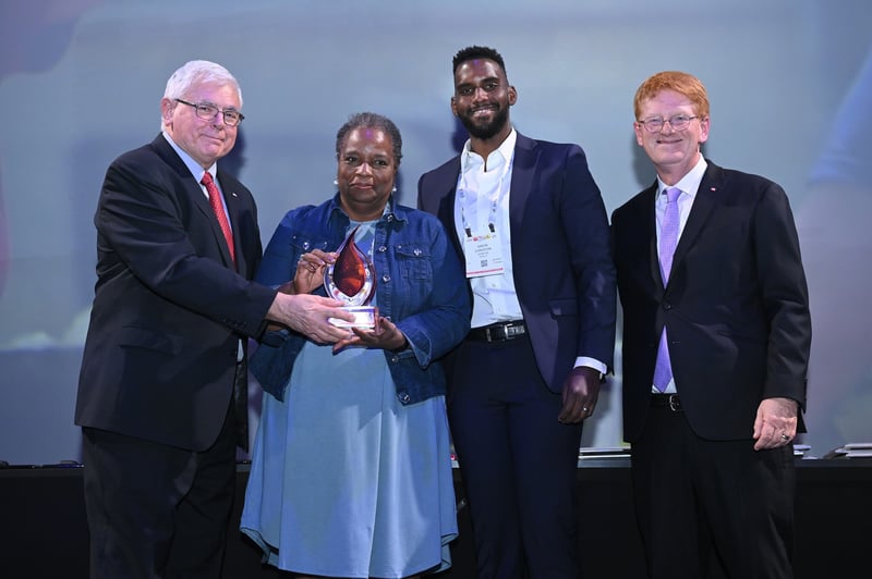 Mark Batenic, Gwen Christon, Simon Christon, John Ross pose for a photo as Gwen receives Spirit of IGA Award