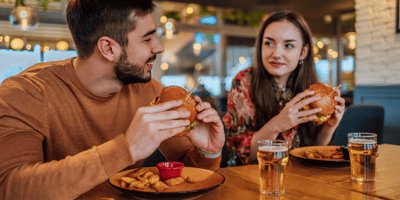 a couple eats burgers at a restaurant