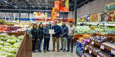 Yong Kim and John Ross hold the Retailer of the Year certificate among the Nam Dae Mun Farmers Market team in the store