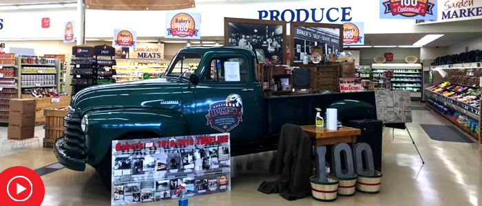 antique car display with 100 numbers celebrating store