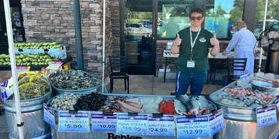 Granite Falls IGA employee stands behind seafood on ice outside the store
