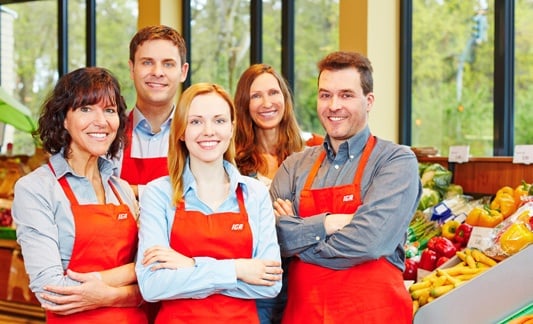 group of iga employees in red aprons