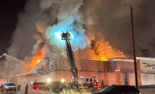 Firefighters try to put out the fire at Martin's Country Market, as plumes of smoke reach high in the sky.