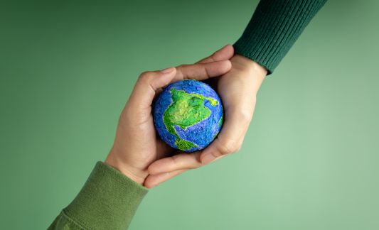 two hands holding a small earth ball