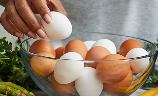 hand picking an egg out of a bowl